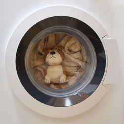 Stuffed toy and clothes in washing machine drum