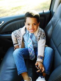 Portrait of smiling boy sitting in car