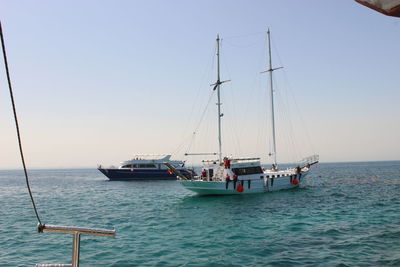 Sailboat sailing on sea against clear sky