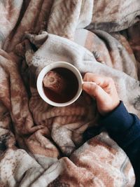 Directly above shot of hand holding coffee cup