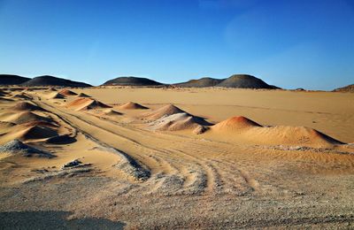 Scenic view of desert against clear blue sky