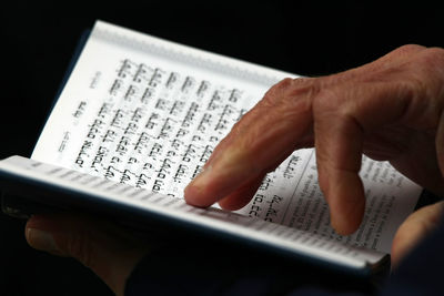 Close-up of hand reading book