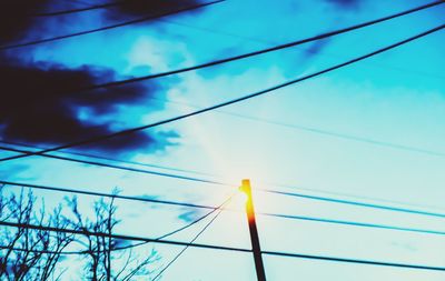 Low angle view of power lines against blue sky