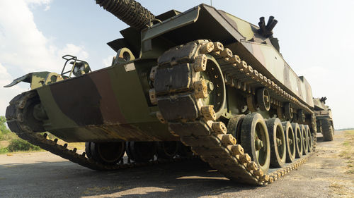 Military tank on field against sky