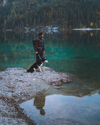 Man standing on rock by lake