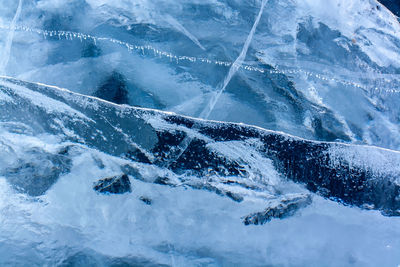 Natural ice texture with cracks and air bubbles. thick blue transparent ice. horizontal.