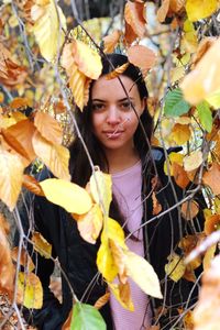 Portrait of young woman with autumn leaves