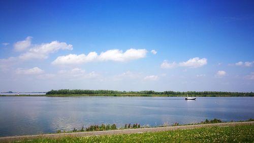 Scenic view of river against cloudy sky