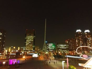 Illuminated cityscape against sky at night