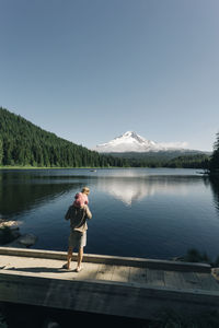 A father carries his daughter on his shoulders at trillium lake, or.