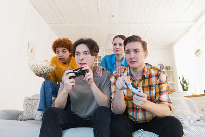 Female friends sitting on sofa at home