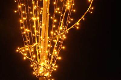 Close-up of illuminated lighting equipment against black background