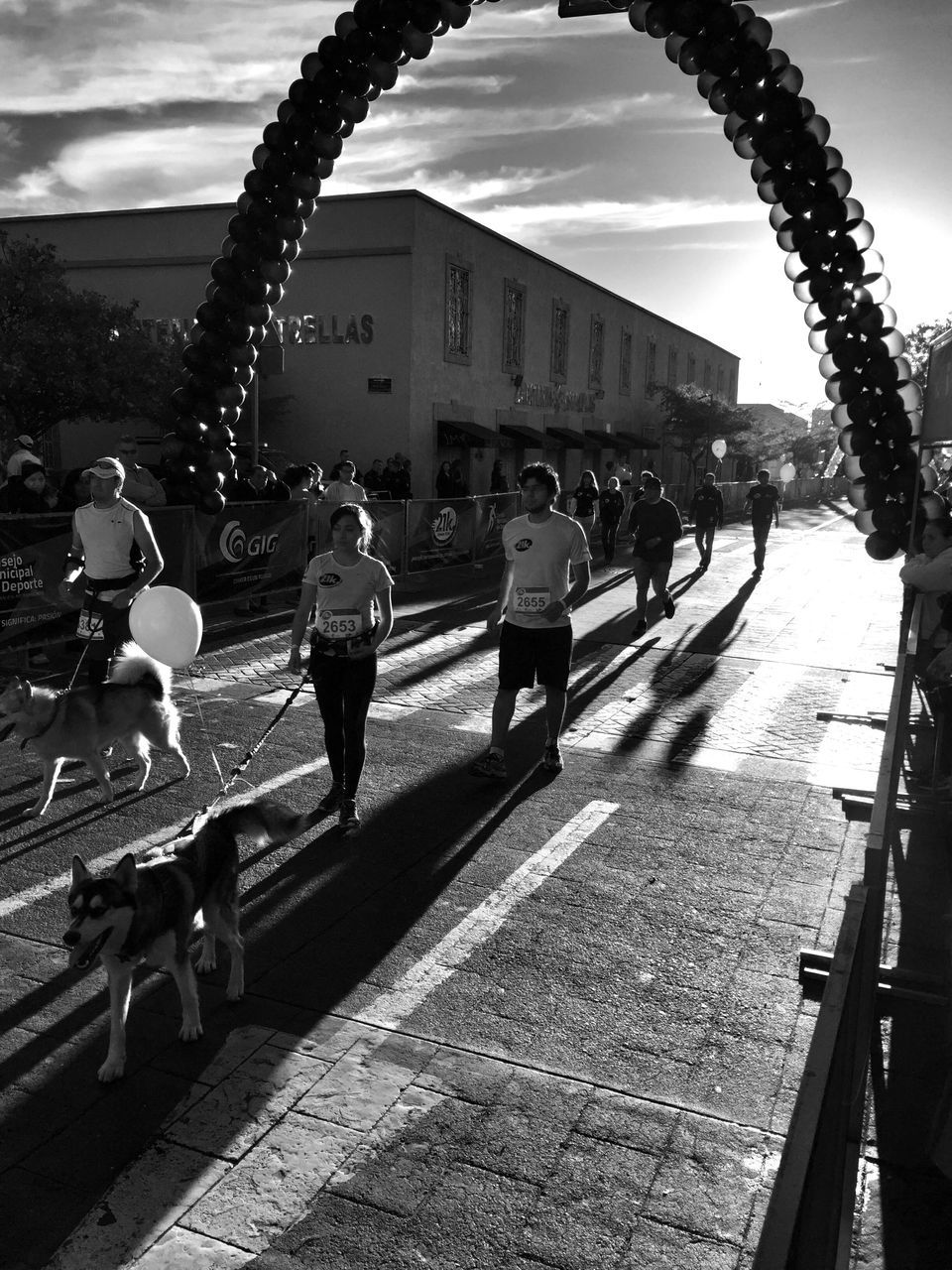 sky, lifestyles, leisure activity, walking, person, large group of people, men, cloud - sky, full length, street, the way forward, mixed age range, cloudy, built structure, cloud, footpath, road, outdoors, railing