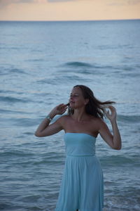 Woman standing against sea at beach