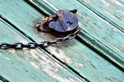 Close-up of rusty chain on wooden door