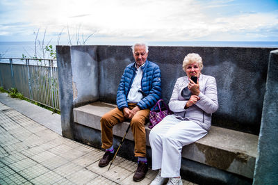 Full length portrait of friends sitting outdoors