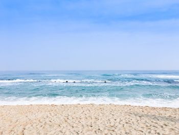 Scenic view of beach against clear blue sky