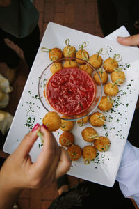 Appetizer plate from above with hand dipping food into sauce