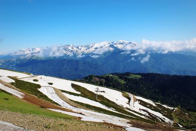 Scenic view of mountains against blue sky