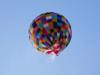 Low angle view of hot air balloon against clear blue sky