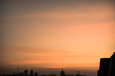 Silhouette cityscape against sky during sunset