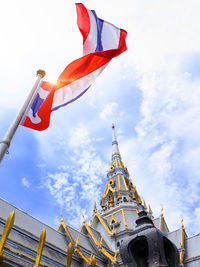 Low angle view of flag on building against sky