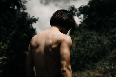 Rear view of shirtless man standing outdoors