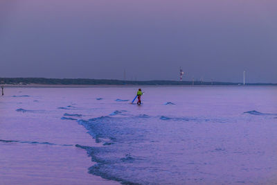 Person skiing on snow covered land against sky