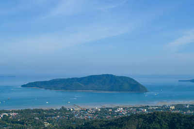 Aerial view of city by sea against sky