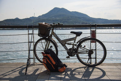 Bicycle by lake against mountains