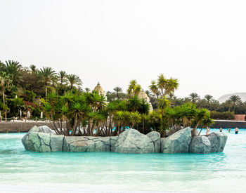 Swimming pool by sea against clear sky