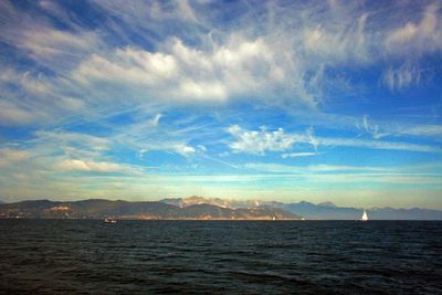 Scenic view of sea and mountains against sky