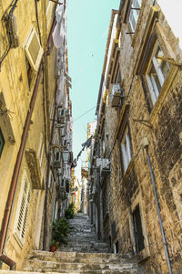 Low angle view of narrow alley amidst buildings in city