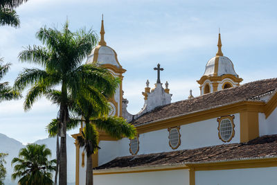 Low angle view of palm trees and building against sky