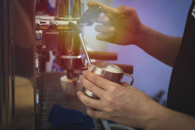 Midsection of man preparing coffee in espresso maker