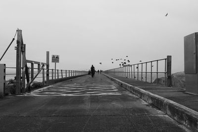 Man walking on street against clear sky