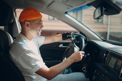 Side view of a man sitting in car