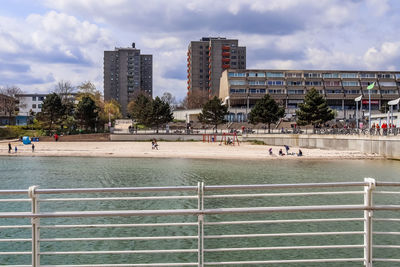 Group of people in park by buildings against sky