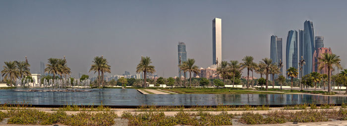 Panoramic view of lake and modern buildings against sky