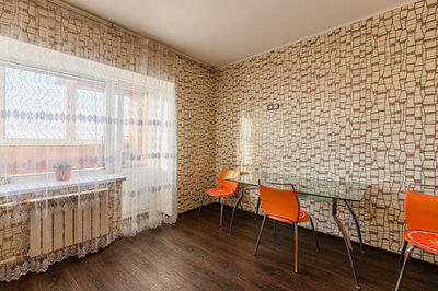 Empty chairs and table against wall at home