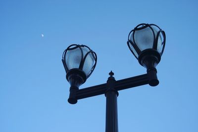 Low angle view of street light against blue sky