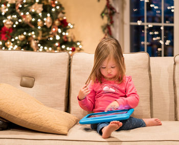 Cute girl sitting on sofa at home