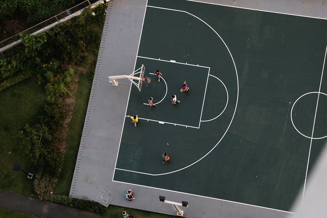 HIGH ANGLE VIEW OF PEOPLE PLAYING SOCCER IN FIELD
