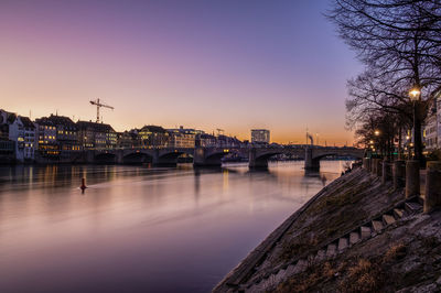 Bridge over river against sky at dusk