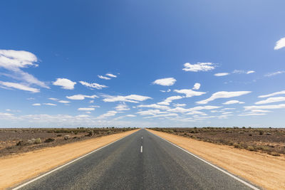 Road passing through land against sky