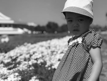 Close-up portrait of cute girl standing by plants