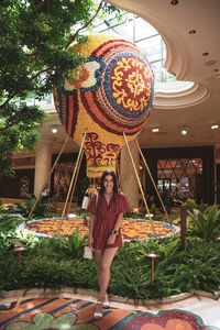 Portrait of woman standing against multi colored plants