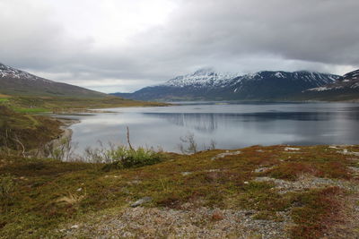 Scenic view of lake and mountains against cloudy sky