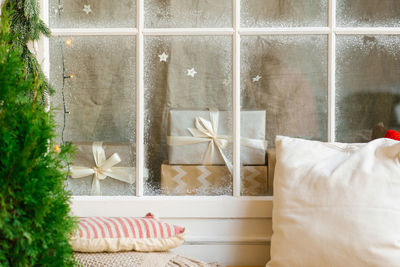 Christmas gifts behind a snow-covered window in the house. christmas card