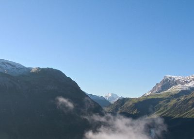 Scenic view of mountains against blue sky